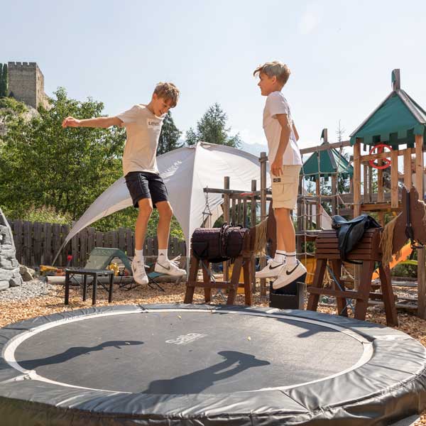 Zwei Jungen springen auf einem Trampolin im Laudeggpark mit Spielplatz und Chill-Out-Areas.