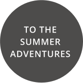 A dark gray circle with the text TO THE SUMMER ADVENTURES in white capital letters.