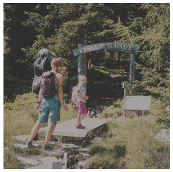 Eine Gruppe von Wanderern, darunter ein Erwachsener und zwei Kinder, spaziert auf einem malerischen Pfad in der Nähe eines Alpenresorts. Sie nähern sich einem hölzernen Torbogen mit der Aufschrift „Lais Gande“. Der Erwachsene trägt einen großen Rucksack und die Kinder folgen ihm dicht auf den Fersen, alles unter einem hellen, sonnigen Himmel.