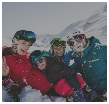 Vier Personen in Winterausrüstung lächeln in Alpenresorts und posieren auf einem verschneiten Berg.